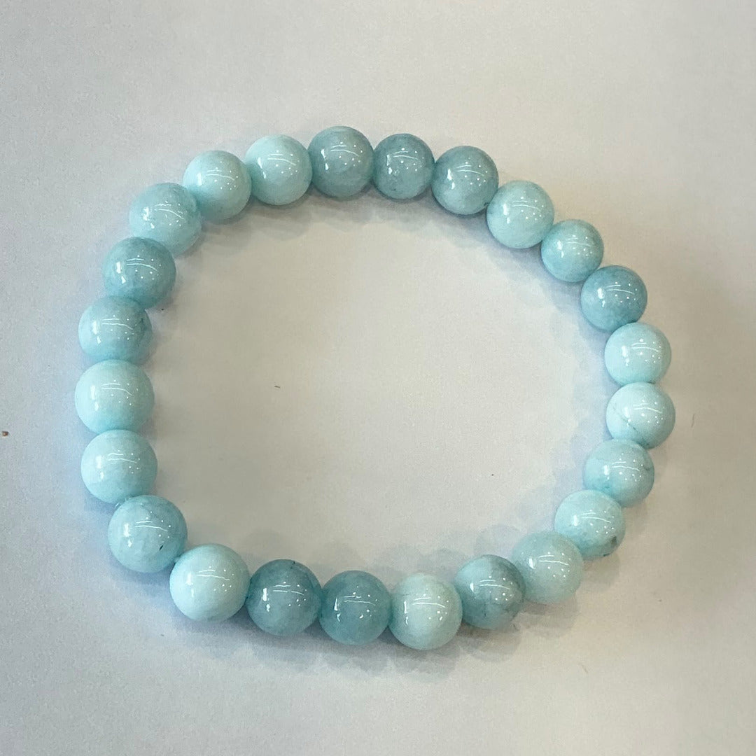 Beaded bracelet made of pale sky blue round stone beads with soft white banding