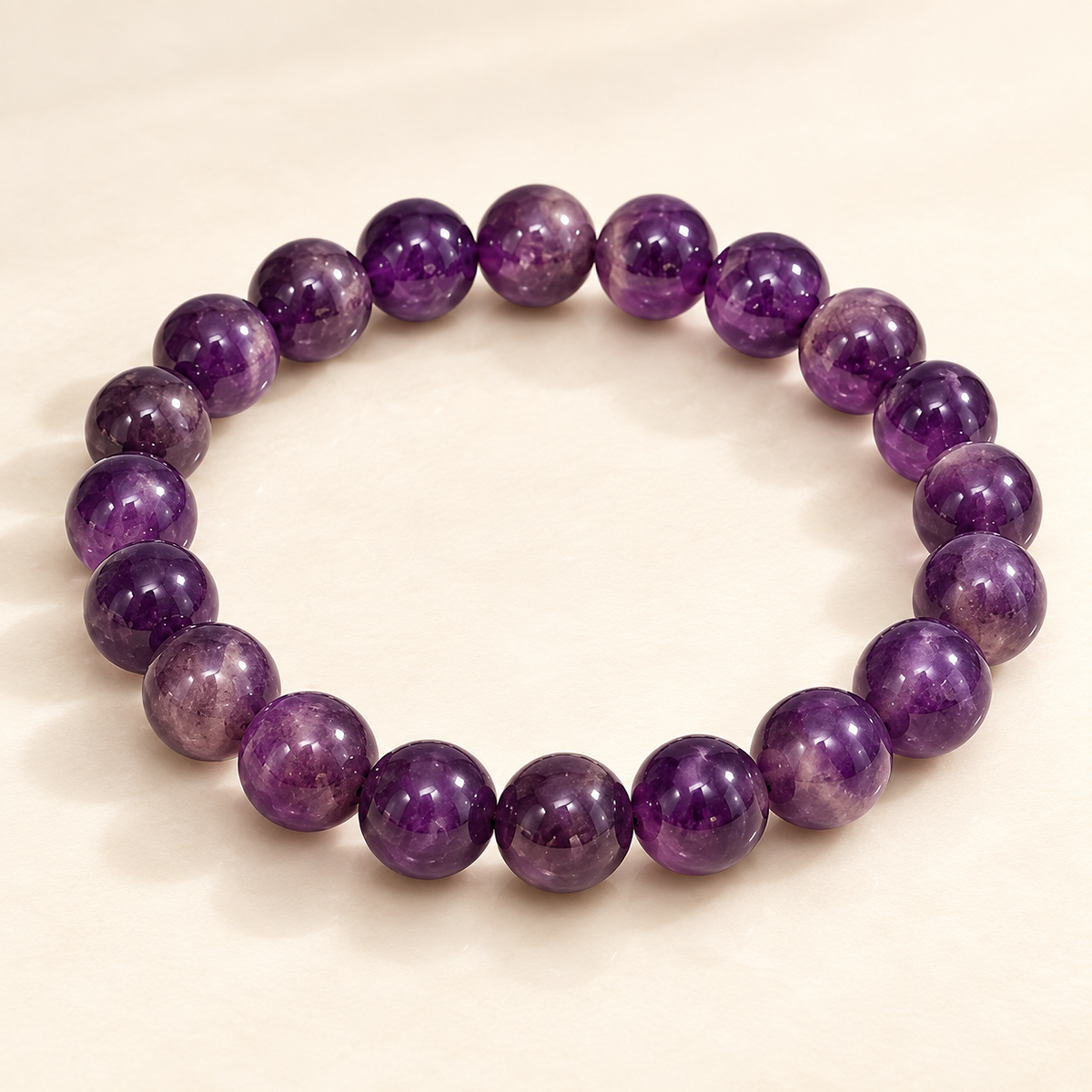 Amethyst Calm & Clarity Bracelet — polished round amethyst beads on a cream background