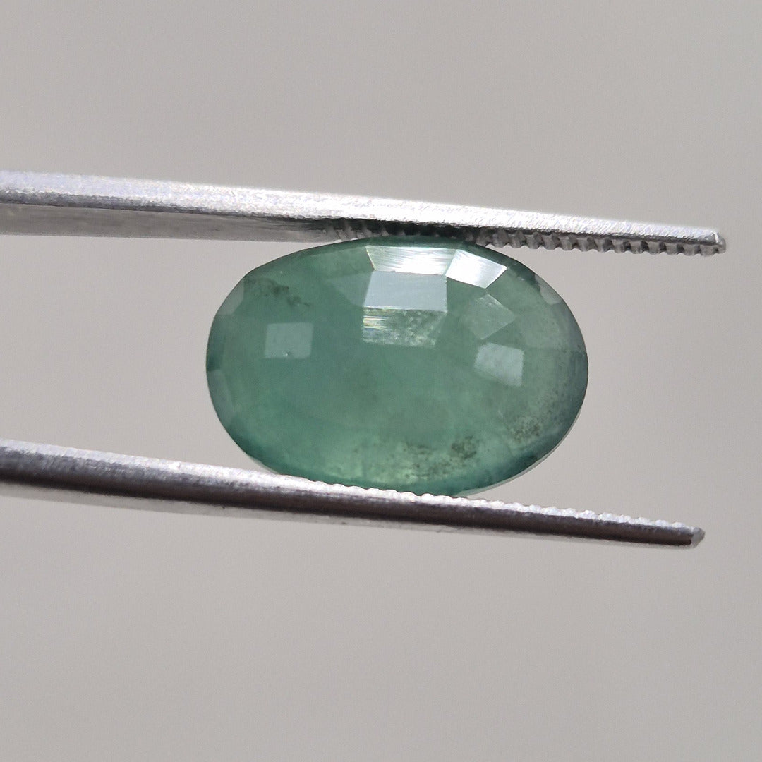 Emerald oval gemstone from a second angle, showing facet arrangement across the crown