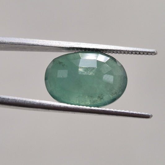 Emerald oval gemstone from a second angle, showing facet arrangement across the crown